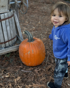 Kaikoa on the farm with a pumpkin